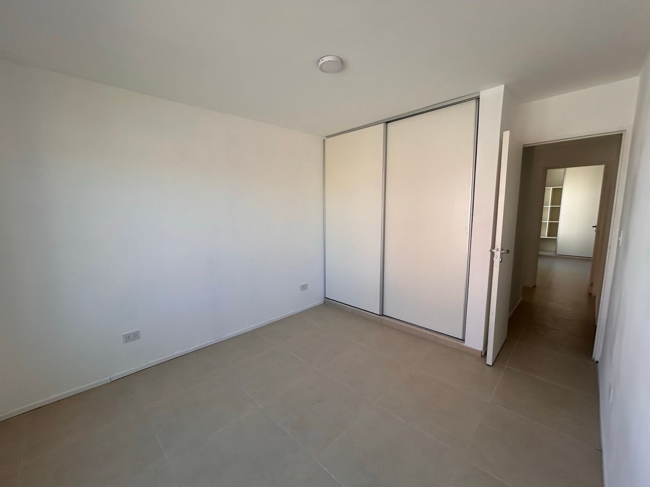 Segundo dormitorio con placard corredizo y vista al pasillo